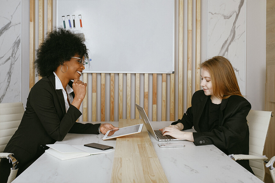 Zwei Frauen sitzen am Tisch und führen ein Gespräch
