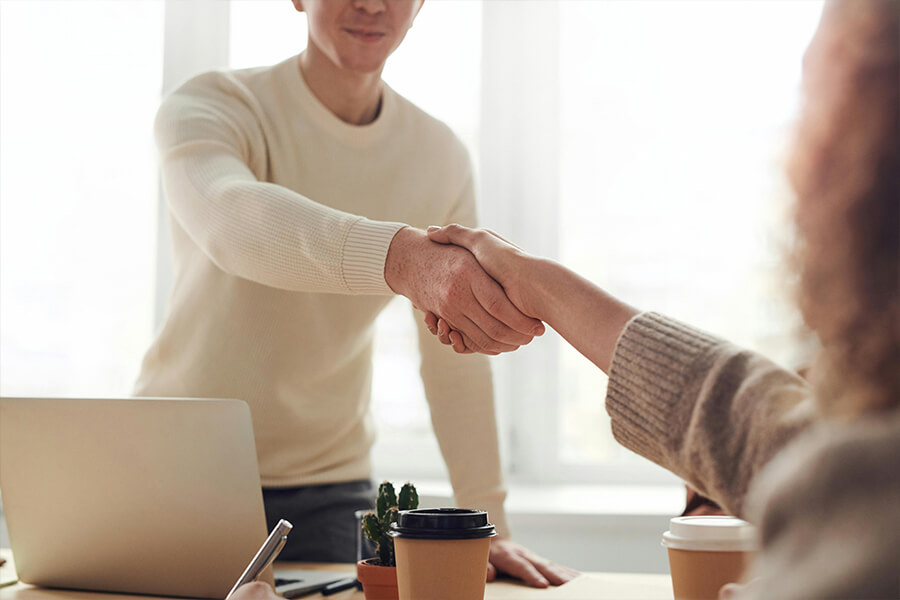 Zwei Personen geben sich einen Handschlag
