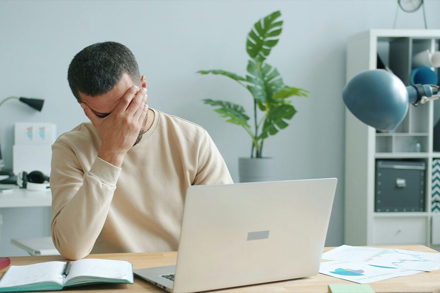 Mann sitzt am Laptop und ist überfordert