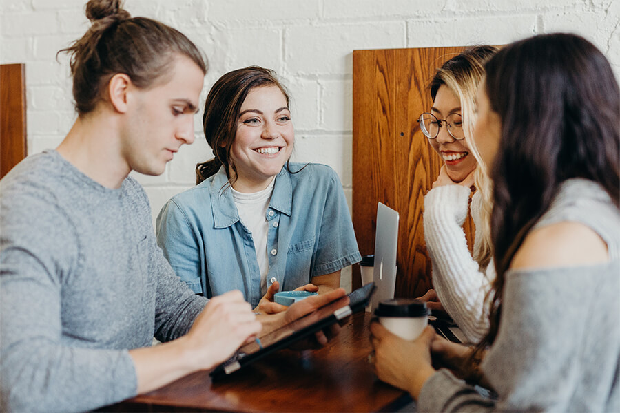 Mehrere Personen sitzen am Tisch und arbeiten