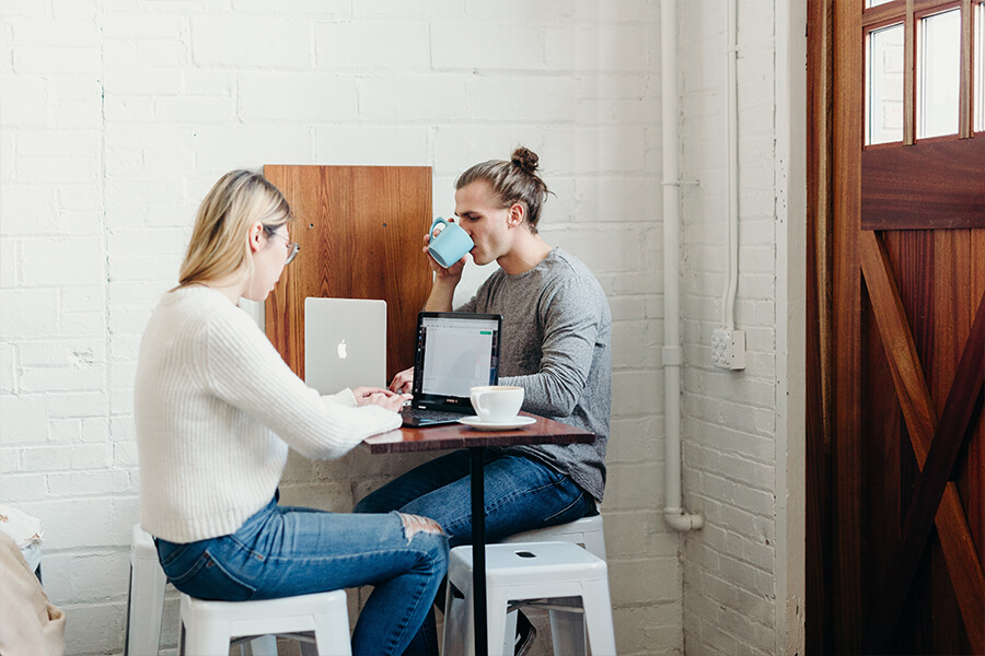 Zwei Personen sitzen am Tisch und arbeiten