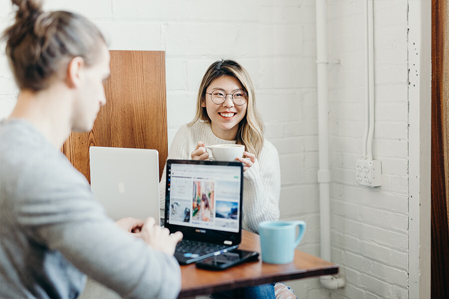 Zwei Personen sitzen am Tisch und arbeiten