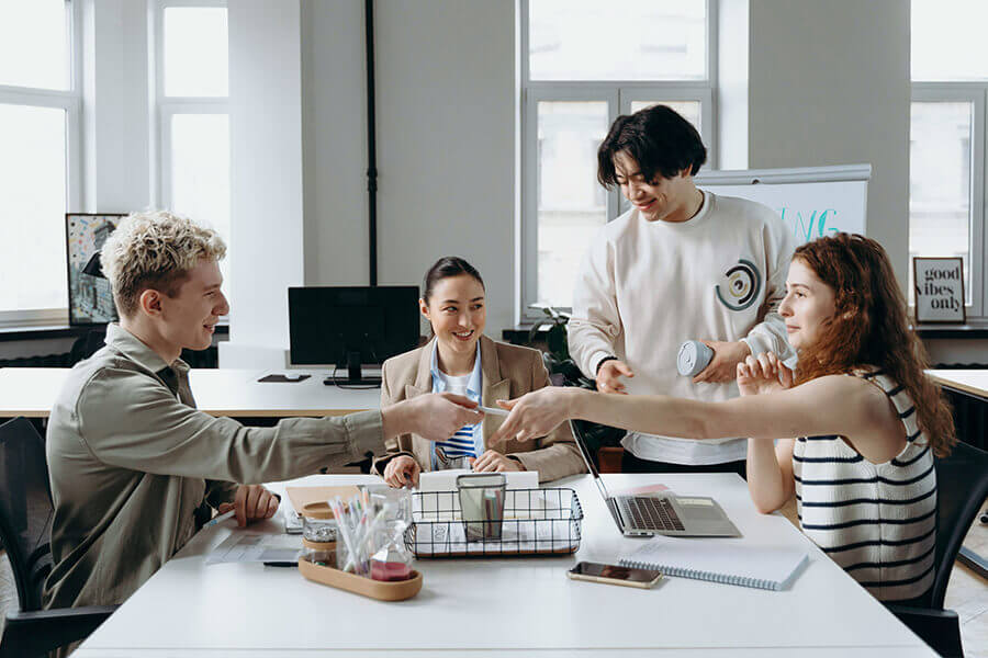 Personen sitzen an einem Tisch und arbeiten